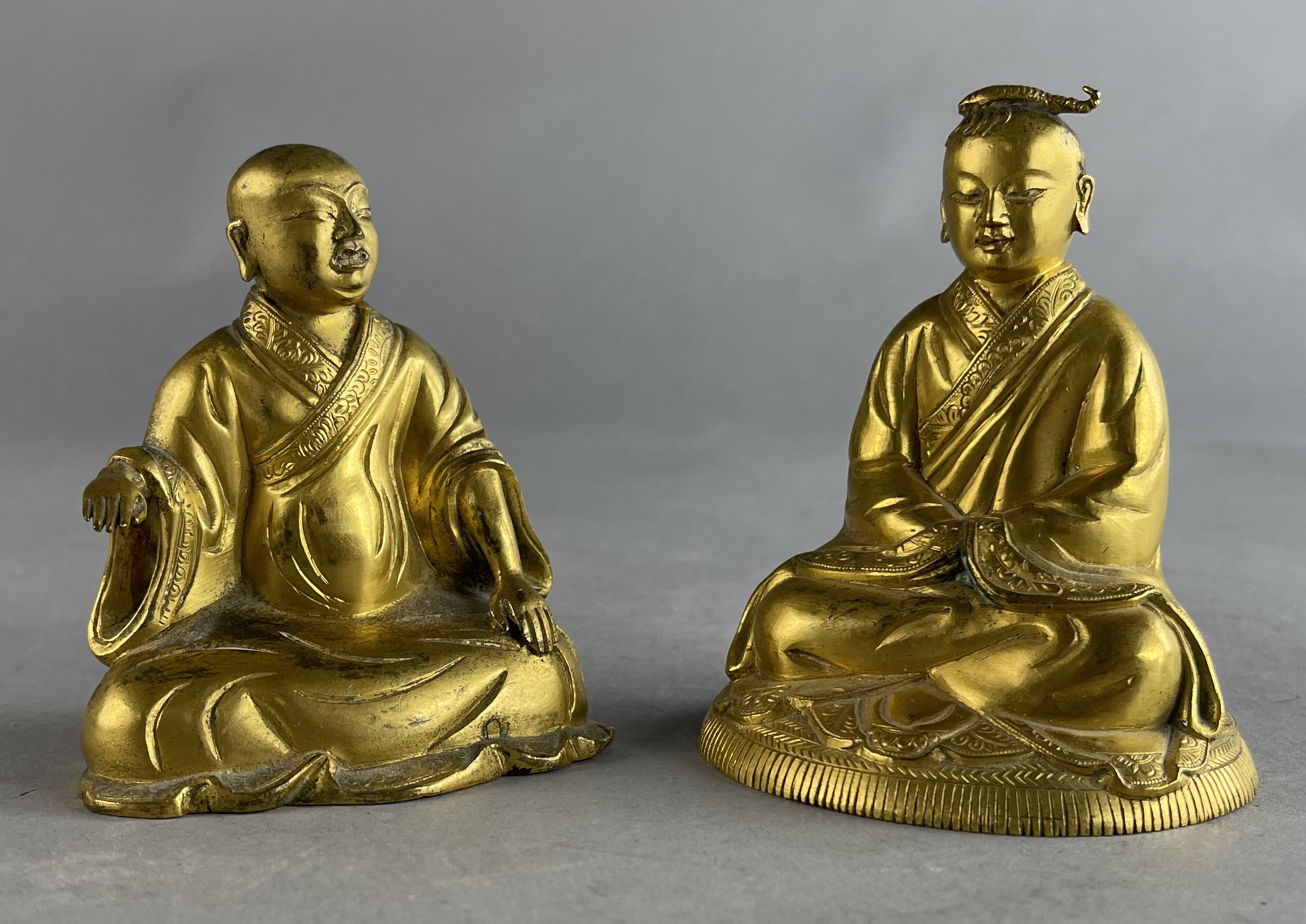 Pair of Buddhist gilt bronze lama figures sold at auction